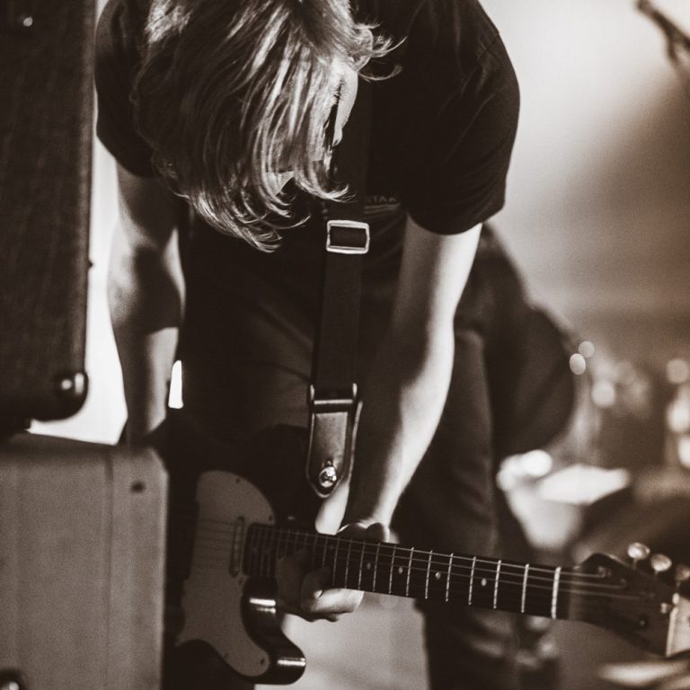 DRAMATIST live at Breminale Bremen Close-up of guitarist bending over electric guitar during live show